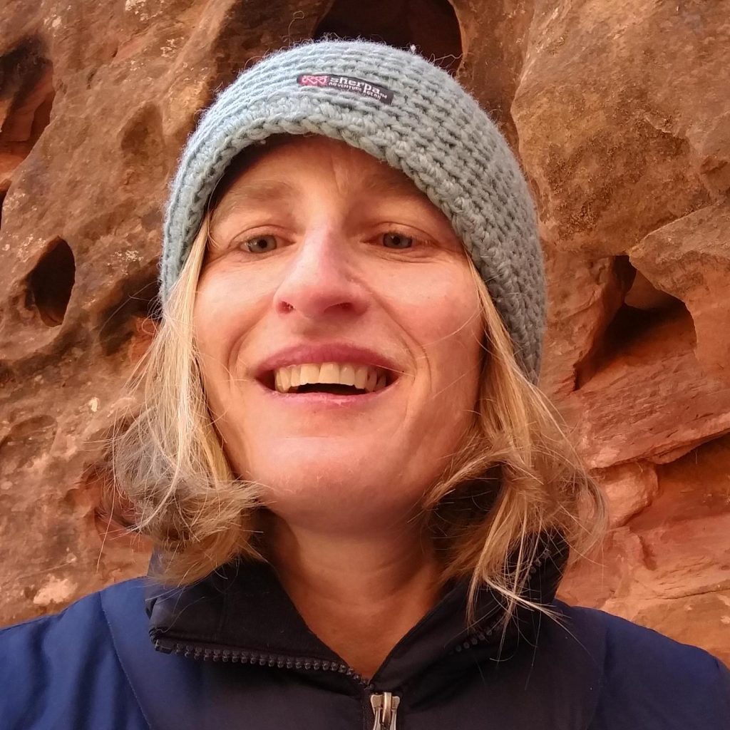 picture of Shawna wearing a beanie standing in front of the red rocks in Utah